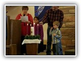 Roger and Sally Brelsford, with their grandchildren Raelyn and Jesse, light the Advent Candles